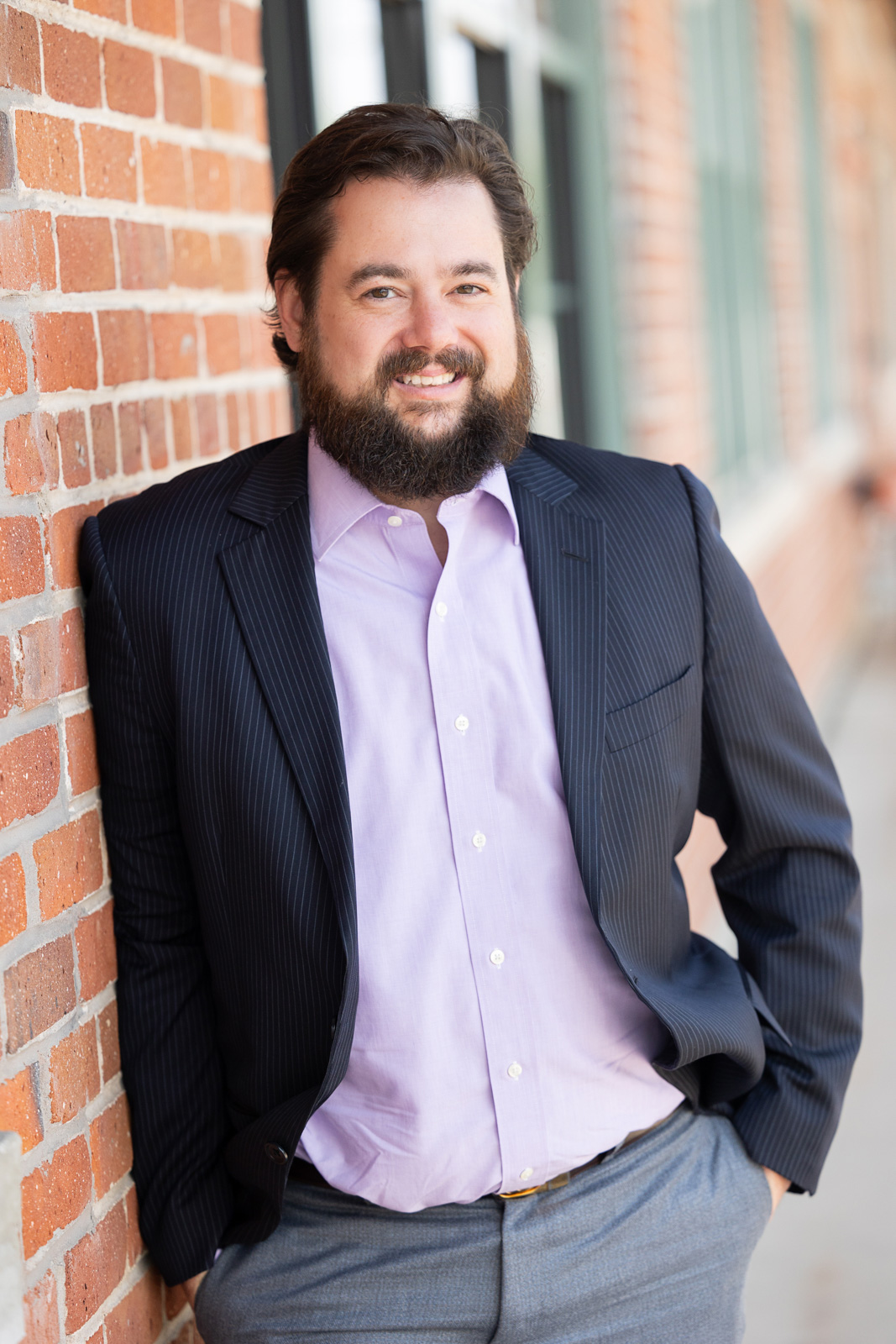 Daniel Kent standing in front of a brick wall